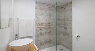 a bathroom with a glass shower and a sink at OurMadeira - Cottage do Mar in Arco da Calheta