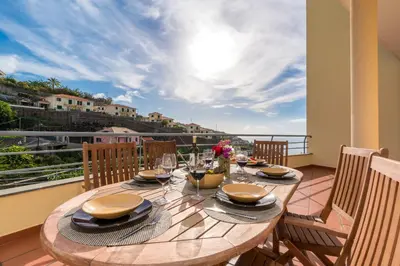 a wooden table on a balcony with a view at Apartamento Serramar , Vistas deslumbrantes in Calheta