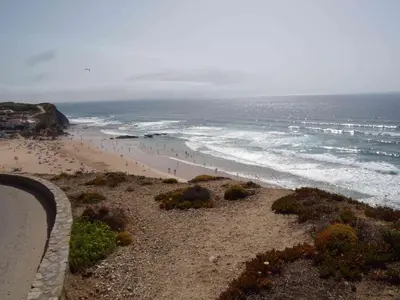 a view of a beach with people in the ocean at Villa Bartoni in Aljezur