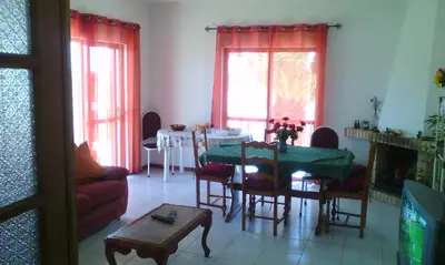 a living room with a table and a dining room at Villa Bartoni in Aljezur