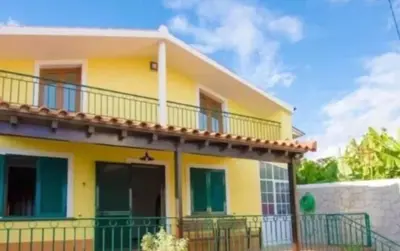 a bedroom with a bed with yellow and blue pillows at House near CR7 Museum in Funchal