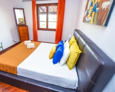 a yellow house with a balcony with tables and chairs at House near CR7 Museum in Funchal