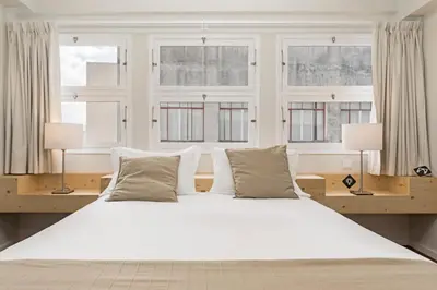 a bedroom with a large white bed with windows at Downtown Funchal Apartments by An Island Apart in Funchal