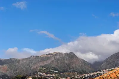 a view of a mountain with clouds in the sky at Downtown Funchal Apartments by An Island Apart in Funchal