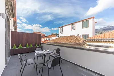 a patio with a table and chairs on a balcony at Downtown Funchal Apartments by An Island Apart in Funchal