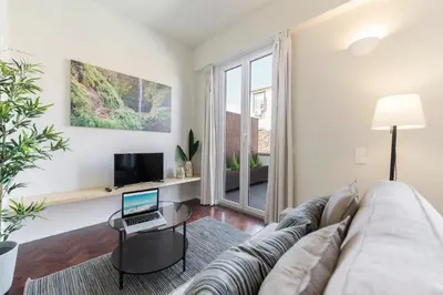 a living room with a couch and a laptop on a table at Downtown Funchal Apartments by An Island Apart in Funchal