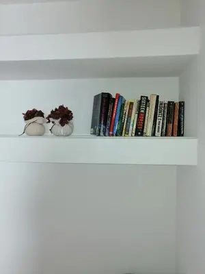 a shelf with books and vases on it at Shearwaters - Sounds of the sea in Funchal