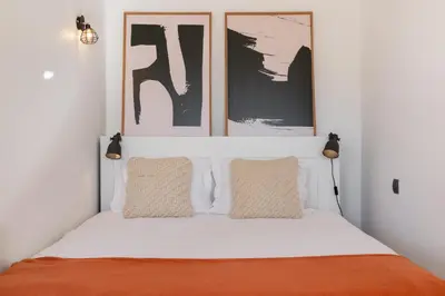 a bedroom with a bed with three pictures on the wall at Varandas do Funchal I by An Island Apart in Funchal