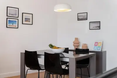 a dining room with a table and black chairs at Varandas do Funchal I by An Island Apart in Funchal