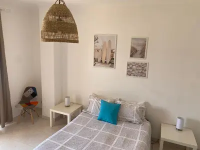 a bedroom with a bed with a blue pillow at Casa Luana - Rooms in Sagres