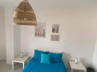 a bedroom with a blue bed and a chandelier at Casa Luana - Rooms in Sagres