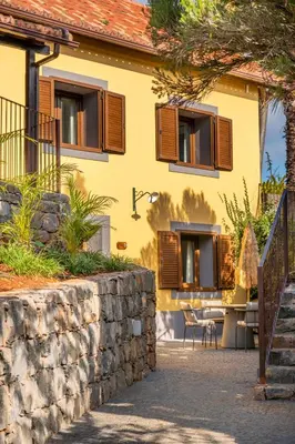 a yellow house with a stone wall at Hotel Quinta Do Furao in Santana