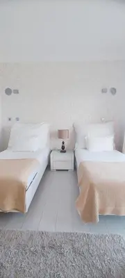 a bedroom with two beds and a table with a lamp at Casa do Mar - Luxurious Villa with Swim Spa & sea view in Luz