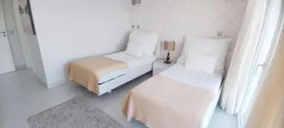 a small bedroom with two beds and a lamp at Casa do Mar - Luxurious Villa with Swim Spa & sea view in Luz