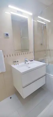 a white bathroom with a sink and a mirror at Casa do Mar - Luxurious Villa with Swim Spa & sea view in Luz