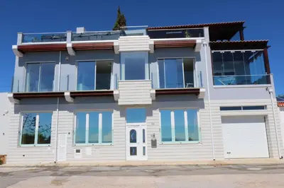 a white house with blue windows at Casa do Mar - Luxurious Villa with Swim Spa & sea view in Luz