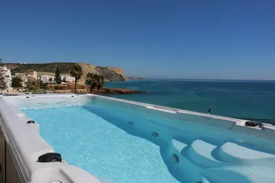 a swimming pool with a view of the ocean at Casa do Mar - Luxurious Villa with Swim Spa & sea view in Luz