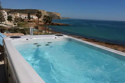 a hot tub with a view of the ocean at Casa do Mar - Luxurious Villa with Swim Spa & sea view in Luz