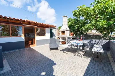 a patio with a table and chairs and a lighthouse at Casa da Mãe do Raivinha in Arco da Calheta