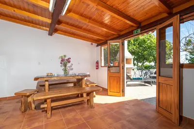 a dining room with a table and a bench at Casa da Mãe do Raivinha in Arco da Calheta