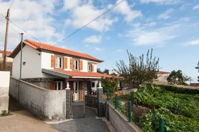 a house with a fence in front of it at Casa da Mãe do Raivinha in Arco da Calheta