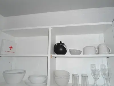 a white cabinet with dishes and wine glasses at Terrace Apartment in Funchal