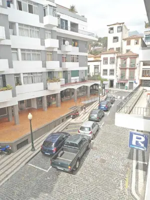a parking lot with cars parked in front of a building at Terrace Apartment in Funchal