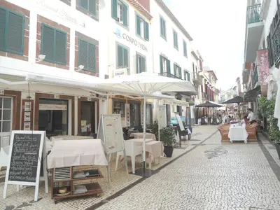 a street with tables and umbrellas on a street at Terrace Apartment in Funchal