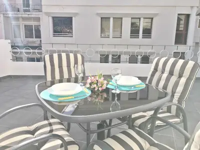 a glass table with two chairs and a table with glasses at Terrace Apartment in Funchal