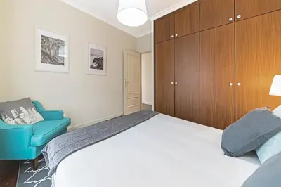 a bedroom with a bed and a blue chair at Arrifes I by An Island Apart in Funchal