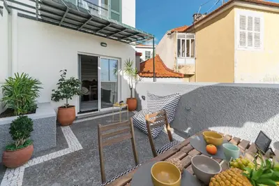 a patio with a table and chairs on a balcony at Arrifes I by An Island Apart in Funchal