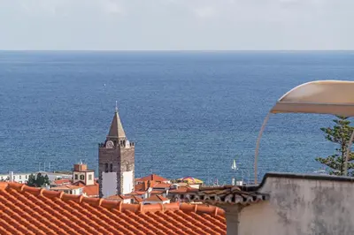 a view of a town with a clock tower and the ocean at Arrifes I by An Island Apart in Funchal