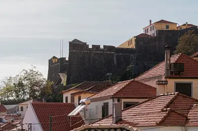 a view of a city with a castle in the background at Arrifes I by An Island Apart in Funchal