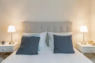 a bedroom with a white bed with two lamps at Arrifes I by An Island Apart in Funchal