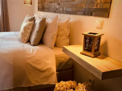 a bedroom with a bed with pillows and a night stand at Herdade Monte Do Sol in Aljezur