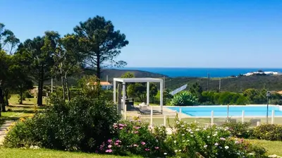 a garden with a swimming pool and flowers at Herdade Monte Do Sol in Aljezur
