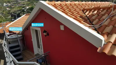 a red house with a red roof with a sign on it at Pink House in Ponta do Sol