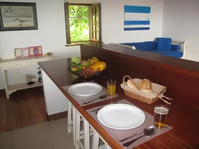 a kitchen with a counter with plates and a bowl of fruit at Faja dos Padres in Ribeira Brava
