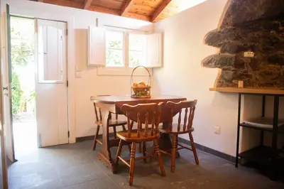 a dining room with a wooden table and chairs at Faja dos Padres in Ribeira Brava