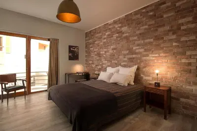 a bedroom with a brick wall and a bed at Ivens Residence in Funchal