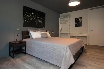 a bedroom with a large bed and a table at Ivens Residence in Funchal