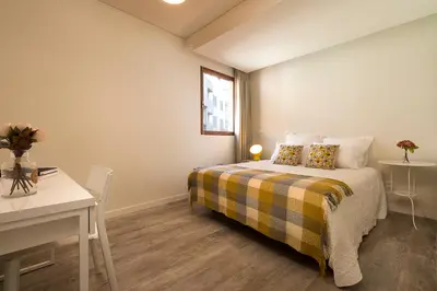 a bedroom with a bed and a desk and a window at Ivens Residence in Funchal