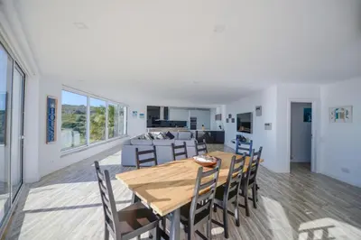 a dining room and living room with a table and chairs at Luz Beach Rooftop Penthouse in Luz