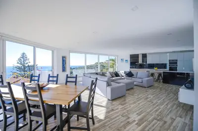 a dining room and living room with a table and chairs at Luz Beach Rooftop Penthouse in Luz