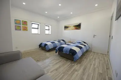 a bedroom with two beds and a couch in it at Luz Beach Rooftop Penthouse in Luz