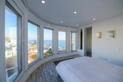 a white room with large windows and a bed at Luz Beach Rooftop Penthouse in Luz