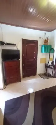 a living room with a tv and a wooden cabinet at Cantinho da Avó in Vila do Bispo