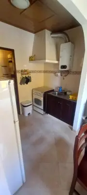 a small kitchen with a stove and a sink at Cantinho da Avó in Vila do Bispo