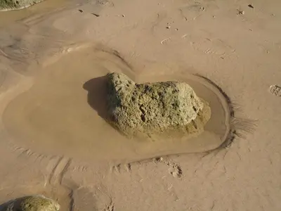 a heart shaped rock in the sand on a beach at Casa Guna in Aljezur