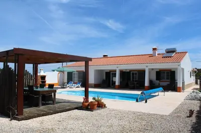 a villa with a swimming pool and a house at Casa Guna in Aljezur